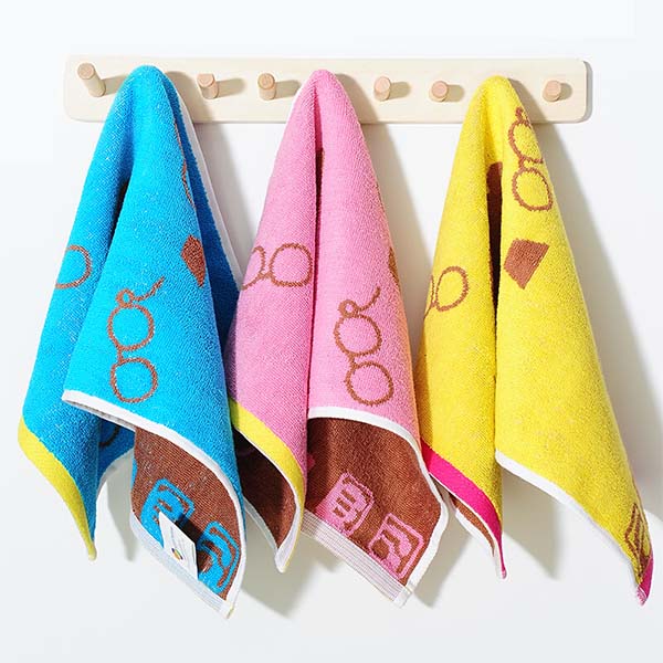 Colourful kids towels with printed designs hanging on hooks
