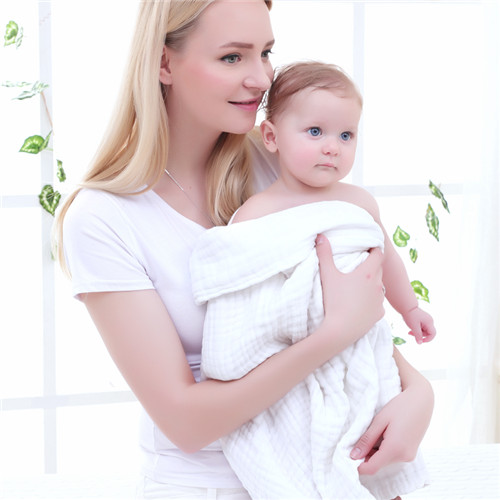 Baby wrapped in a white muslin gauze bath towel