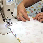 Sewing operator stitching fabric on an industrial machine