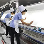 fabric-inspection Workers inspecting fabric on an inspection machine